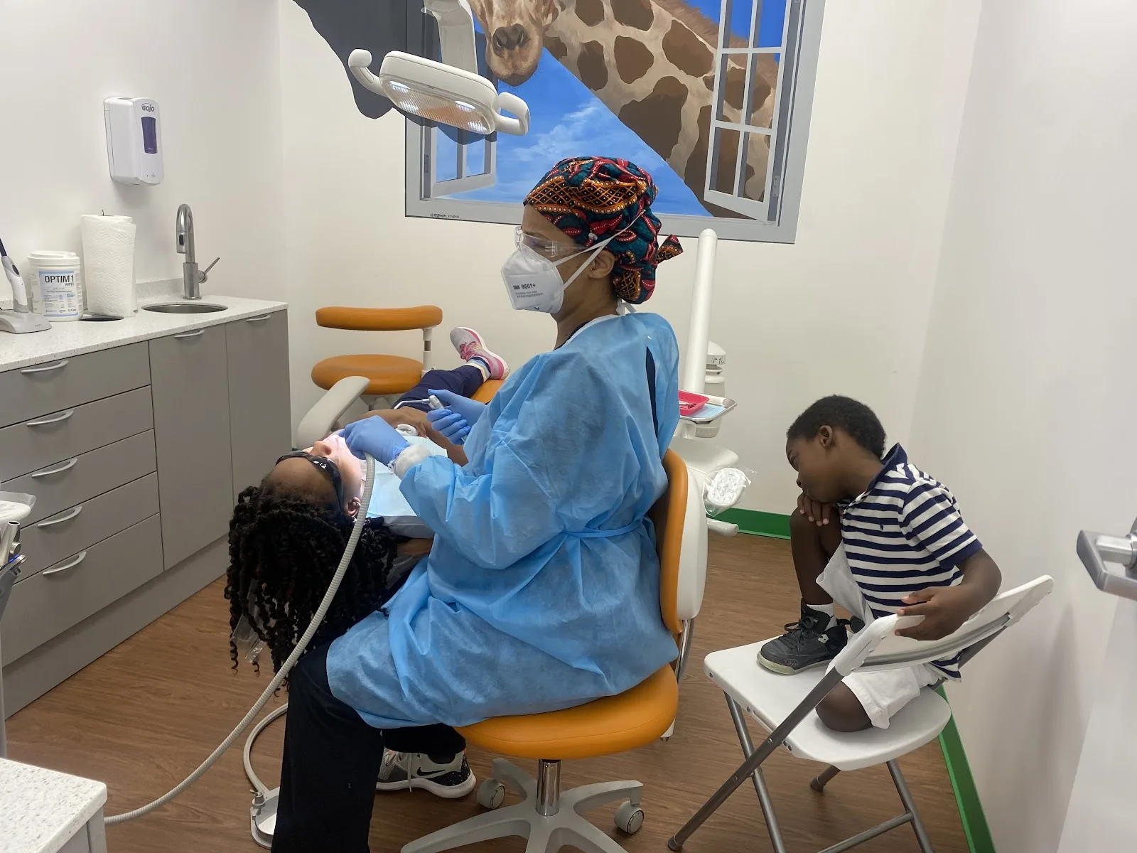 A gentle cleaning under the giraffe mural at Dental Safari in Snellville